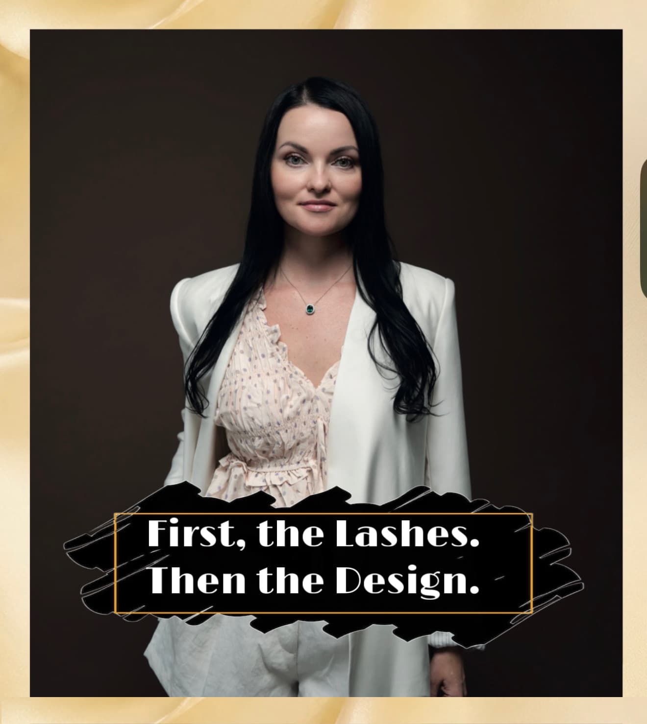A portrait of a woman with long dark hair wearing a white blazer and a patterned top, standing against a dark background. A stylized black brushstroke graphic with a gold border is overlaid on the image, featuring the white text: "First, the Lashes. Then the Design."